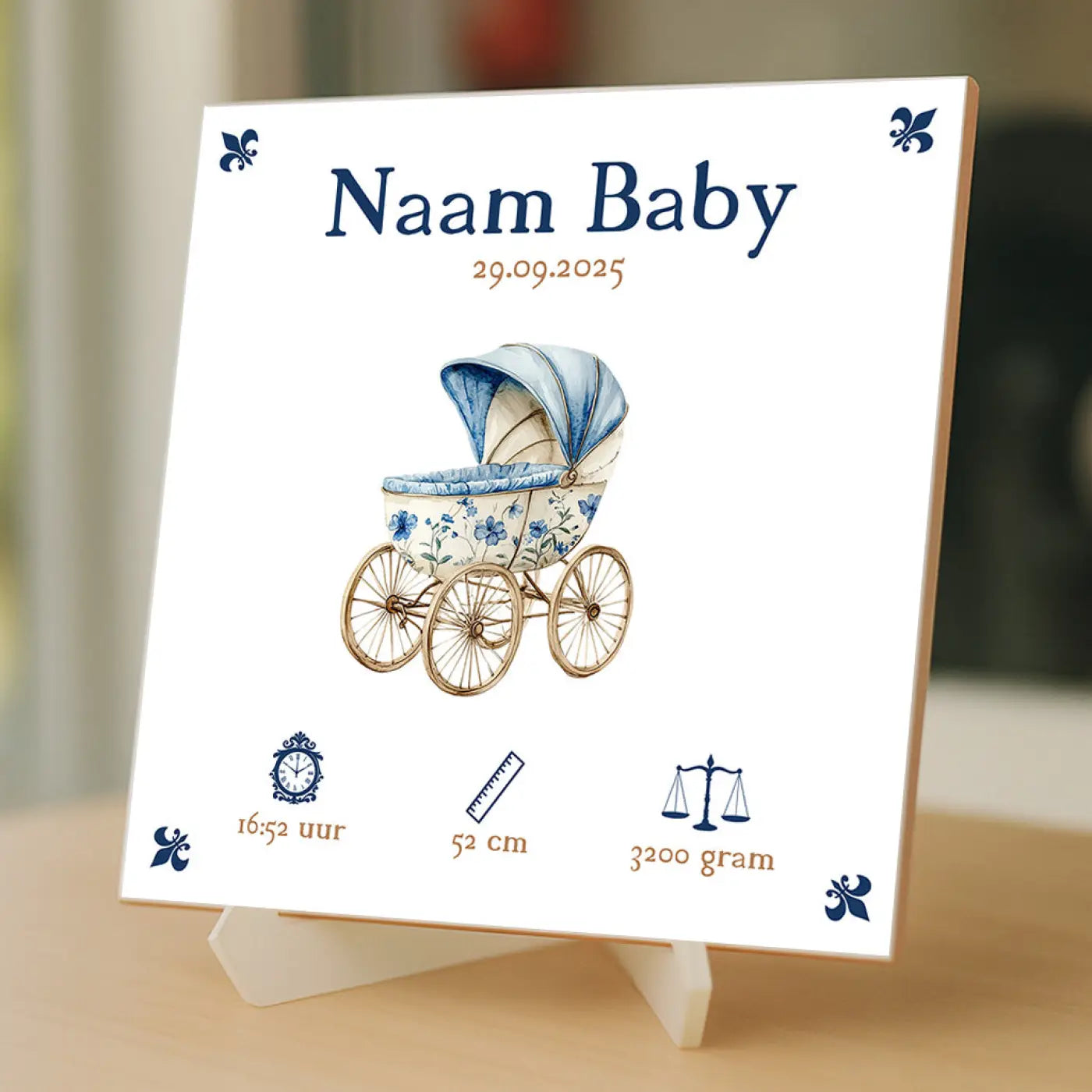 Een wit keramisch baby tegeltje met een blauw crèmekleurige kinderwagen en marineblauwe fleur-de-lis accenten