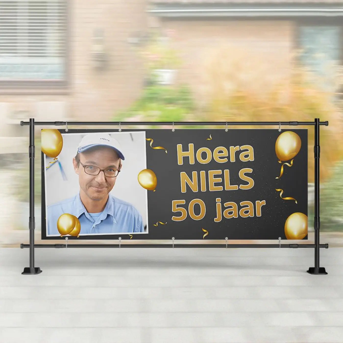 Zwart spandoek abraham verjaardag met gouden folielettering en ballon en foto van man met witte pet