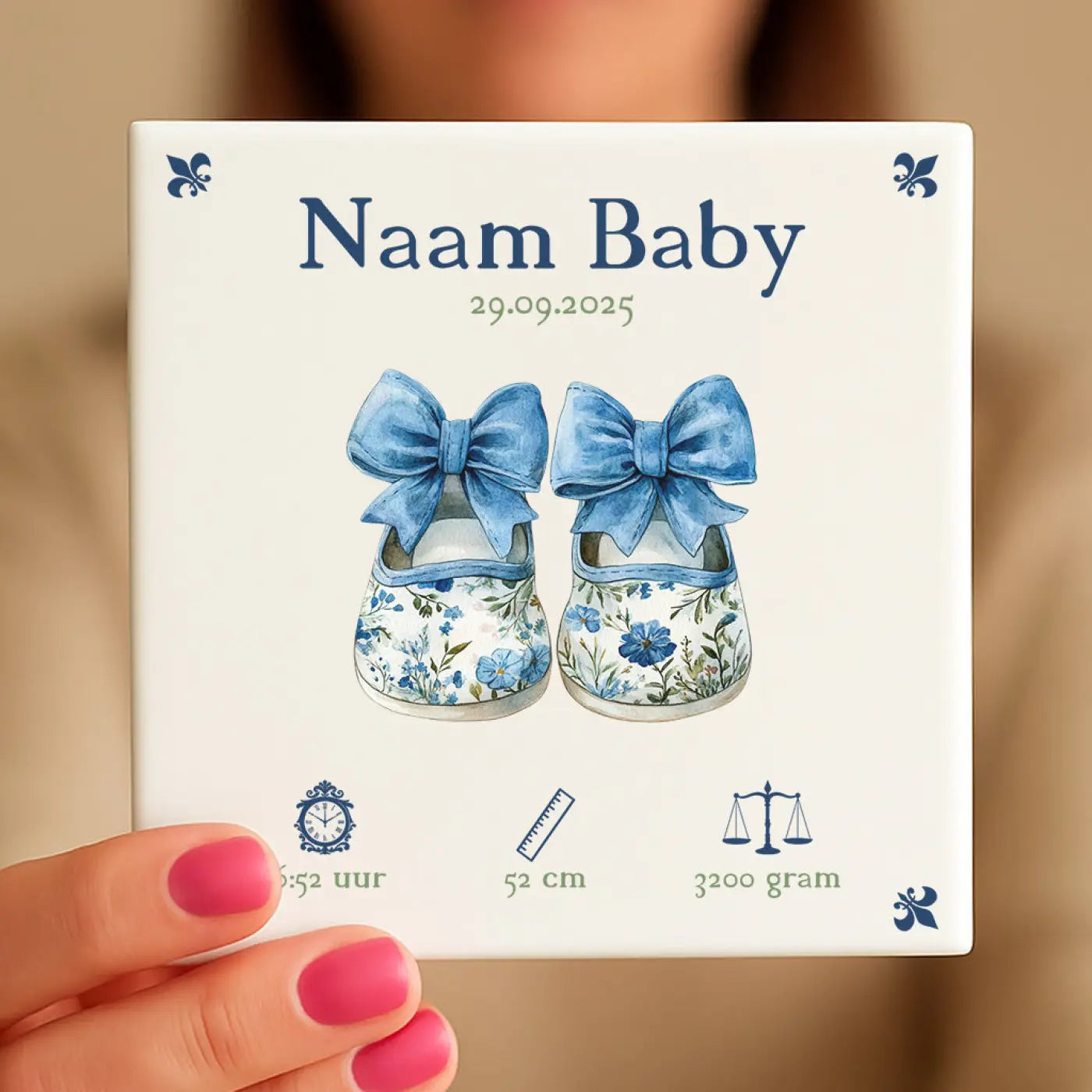 Witte keramische baby tegel met blauwe bloemige babyschoentjes en tekst naam baby en geboortedetails