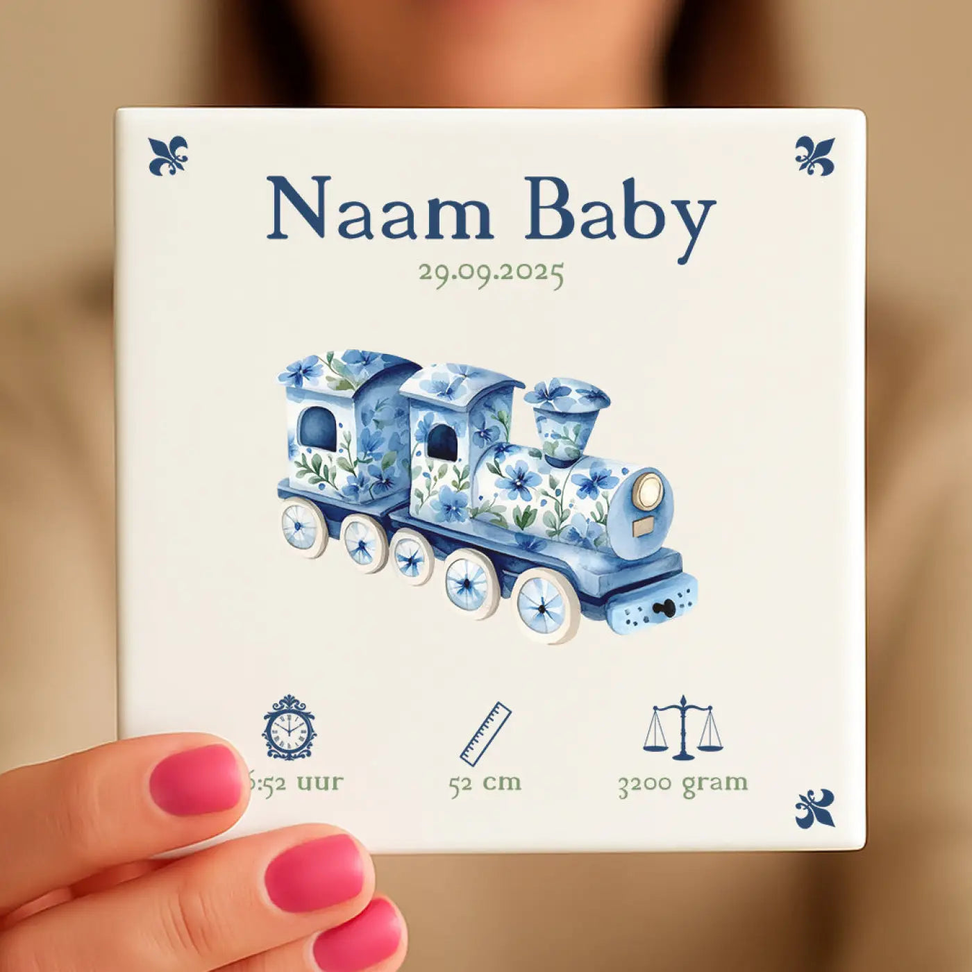 Een wit keramisch baby tegeltje met blauw floral treintje ontwerp navy tekst en fleur-de-lis accenten